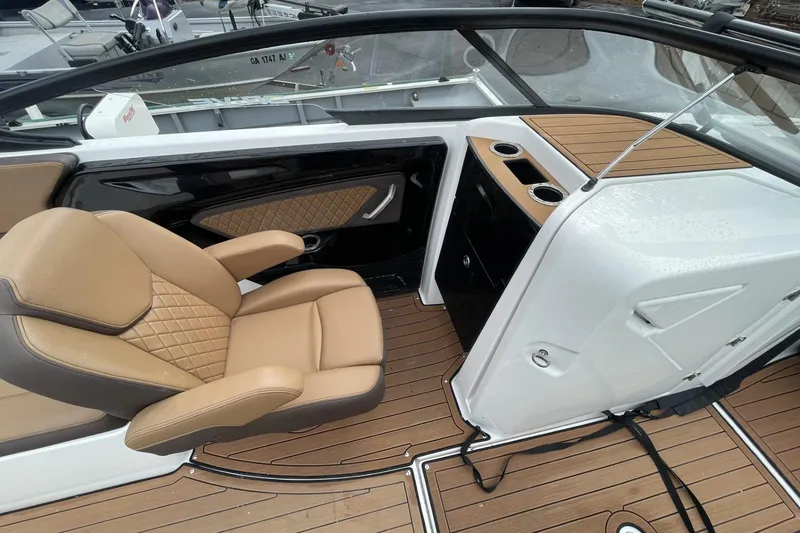 Slide: The Image of Luxurious interior of 2025 Yamaha Boats 252SD with tan seating and wood accents. - 9