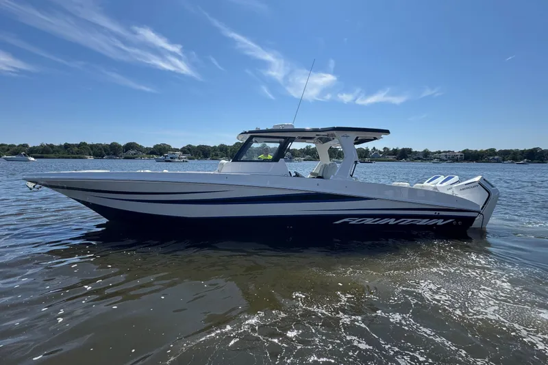 The Image of 2025 Fountain 38 SCX boat on calm water under clear blue sky. - 0