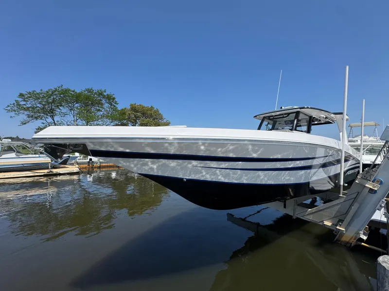 Slide: The Image of 2025 Fountain 38 SCX boat docked on a sunny day, reflecting on water. - 10