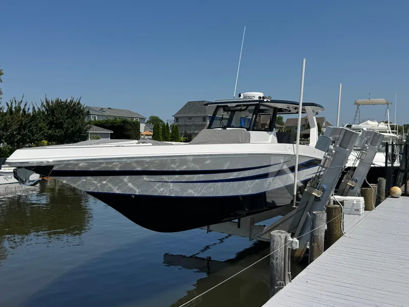 Slide: The Image of 2025 Fountain 38 SCX boat docked on a sunny day, reflecting on water. - 11