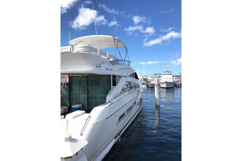 Slide: The Image of Luxury Fairline Squadron 55 yacht docked at marina, 2010 model, under clear blue sky. - 2