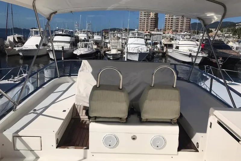 Slide: The Image of Flybridge of 2010 Fairline Squadron 55 yacht in marina, featuring dual seats and canopy. - 7