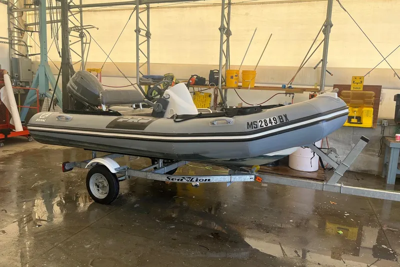 Slide: The Image of 2010 Zodiac Bayrunner 420 inflatable boat on trailer in a workshop setting. - 1