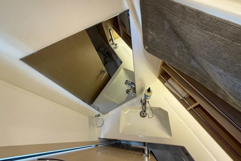Slide: The Image of Bathroom interior of 2021 Beneteau Oceanis 30.1 yacht, featuring a modern sink and mirror. - 12