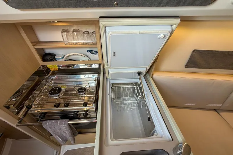Slide: The Image of Beneteau Oceanis 30.1 yacht kitchen with stove, fridge, and storage, 2021 model. - 20