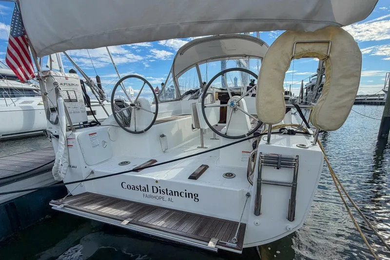 Slide: The Image of Beneteau Oceanis 30.1 sailboat docked, featuring dual steering wheels and American flag. - 38