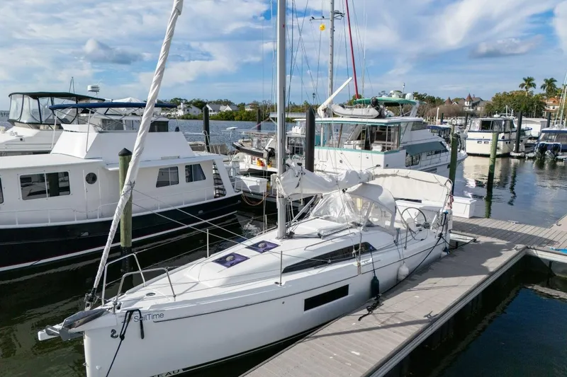 Slide: The Image of 2021 Beneteau Oceanis 30.1 sailboat docked at a marina, surrounded by other boats. - 48