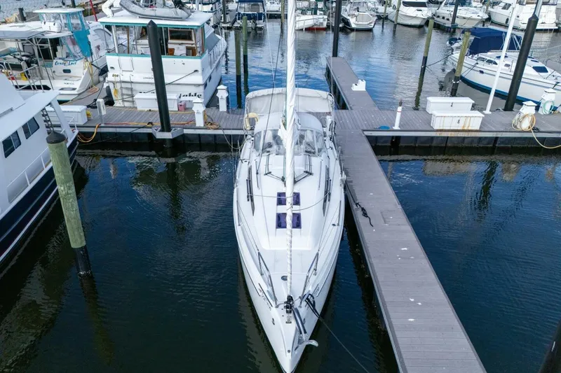 Slide: The Image of 2021 Beneteau Oceanis 30.1 sailboat docked at a marina, surrounded by other boats. - 57