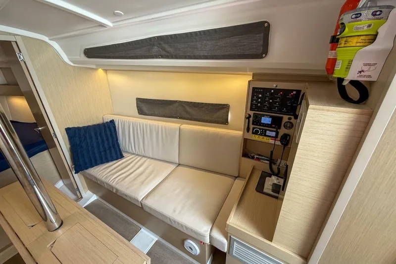Slide: The Image of Interior of 2021 Beneteau Oceanis 30.1 yacht with beige seating and control panel. - 6