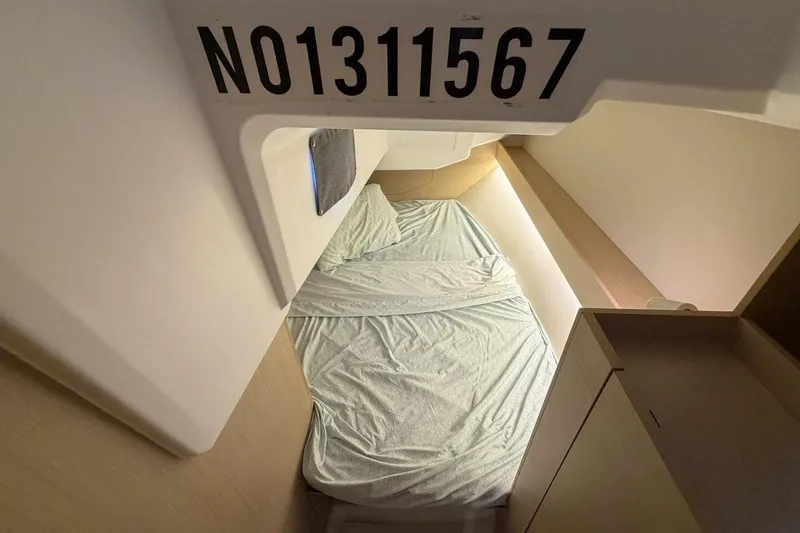 Slide: The Image of Cozy cabin interior of 2021 Beneteau Oceanis 30.1 sailboat with bed and storage. - 7