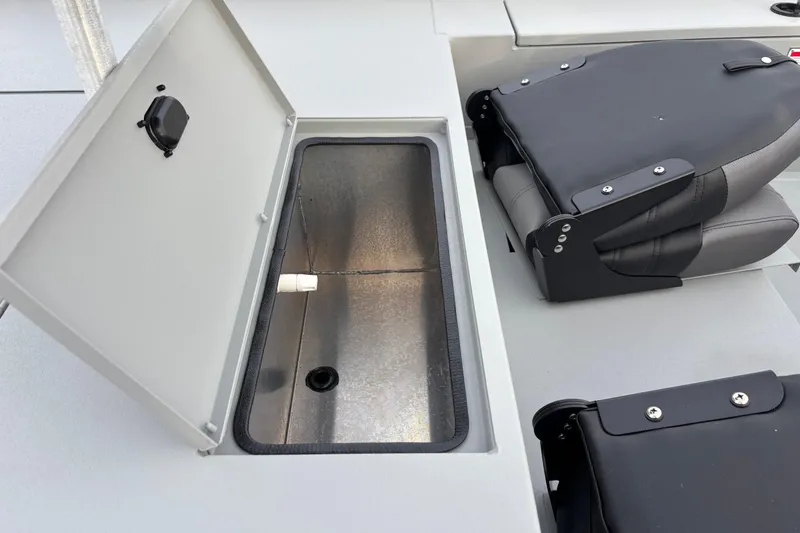 Slide: The Image of 2026 Crestliner 1600 Storm boat interior with open storage compartment and folded seat. - 7