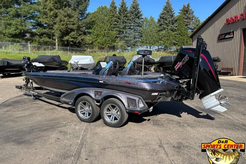 Slide: The Image of 2025 Ranger Z520R boat with trailer at D&R Sports Center, surrounded by trees. - 2