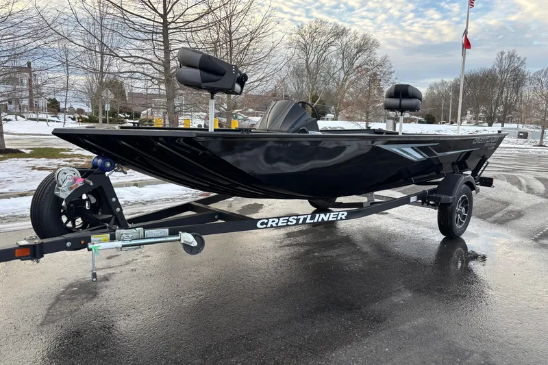 The Image of 2026 Crestliner 1700 Storm boat on trailer, parked on wet pavement with snowy background. - 0