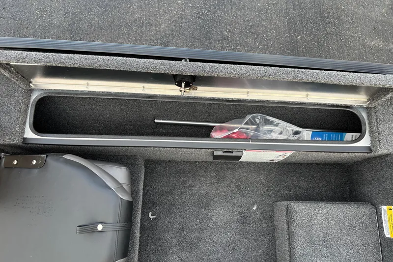 Slide: The Image of Storage compartment in 2026 Crestliner 1700 Storm boat, featuring carpeted interior and secure latch. - 4