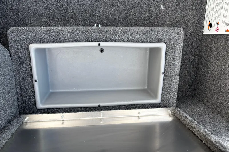 Slide: The Image of Storage compartment in 2026 Crestliner 1700 Storm boat, featuring gray interior and carpeted edges. - 5