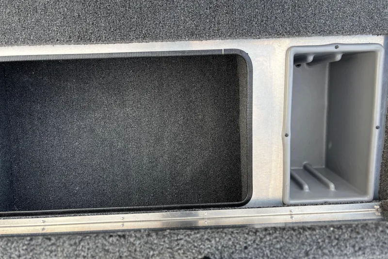Slide: The Image of 2026 Crestliner 1700 Storm boat storage compartments, featuring carpeted and metal finishes. - 6