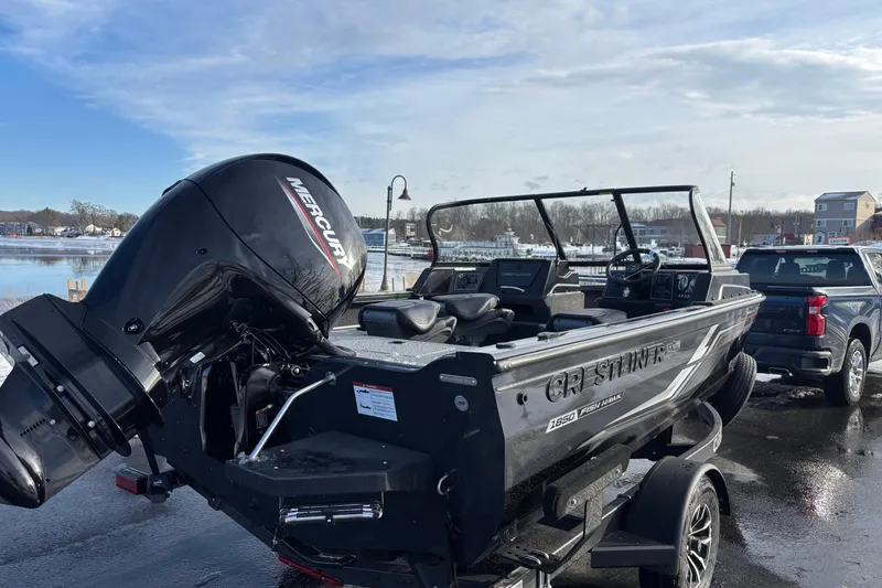 Slide: The Image of 2026 Crestliner 1850 Fish Hawk WT JS boat with Mercury engine, parked near a lake. - 15