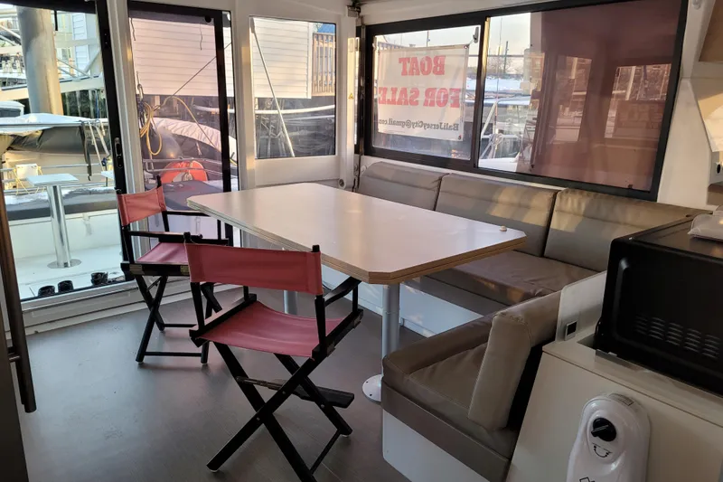 Slide: The Image of Interior of 2019 Bali 4.3 catamaran with dining area and "Boat for Sale" sign. - 10