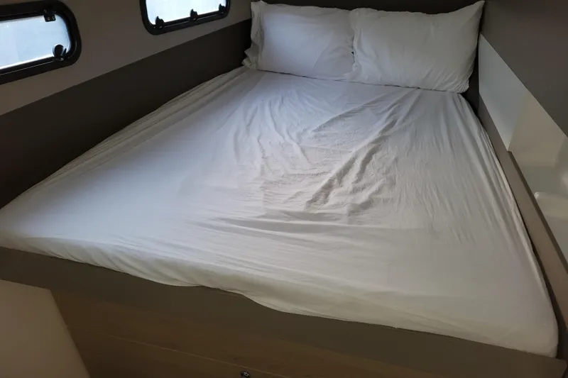 Slide: The Image of Bed inside a 2019 Bali 4.3 model, featuring white linens and compact design. - 43
