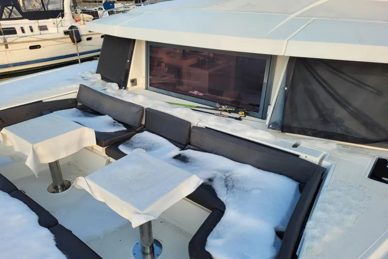 Slide: The Image of Snow-covered seating area on a 2019 Bali 4.3 catamaran, docked at a marina. - 63
