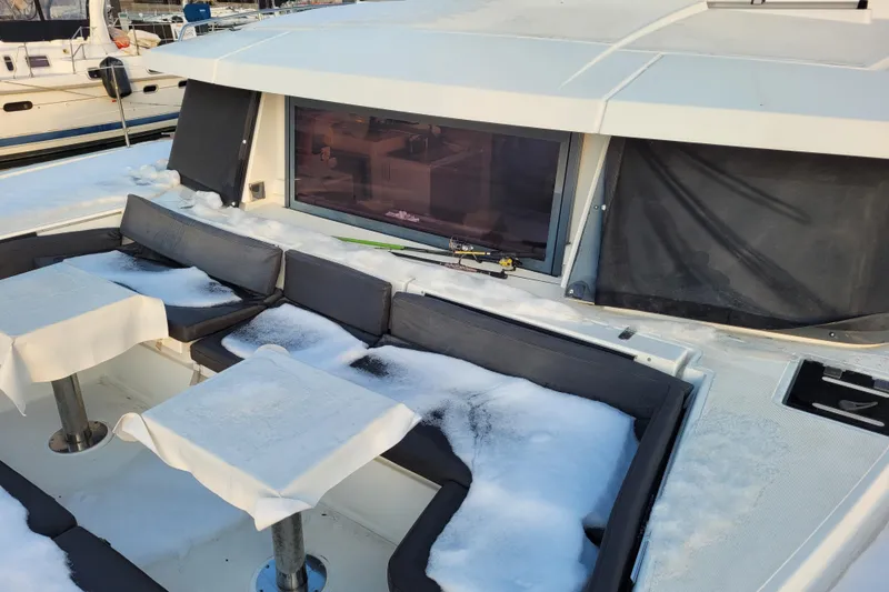 Slide: The Image of Snow-covered deck of a 2019 Bali 4.3 catamaran with seating and tables. - 64