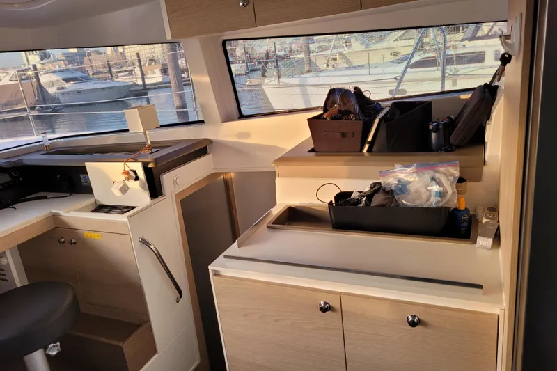 Slide: The Image of Interior of a 2019 Bali 4.3 catamaran with organized storage and marina view. - 7