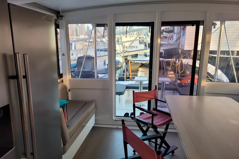 Slide: The Image of Interior of a 2019 Bali 4.3 catamaran with seating, table, and marina view. - 9