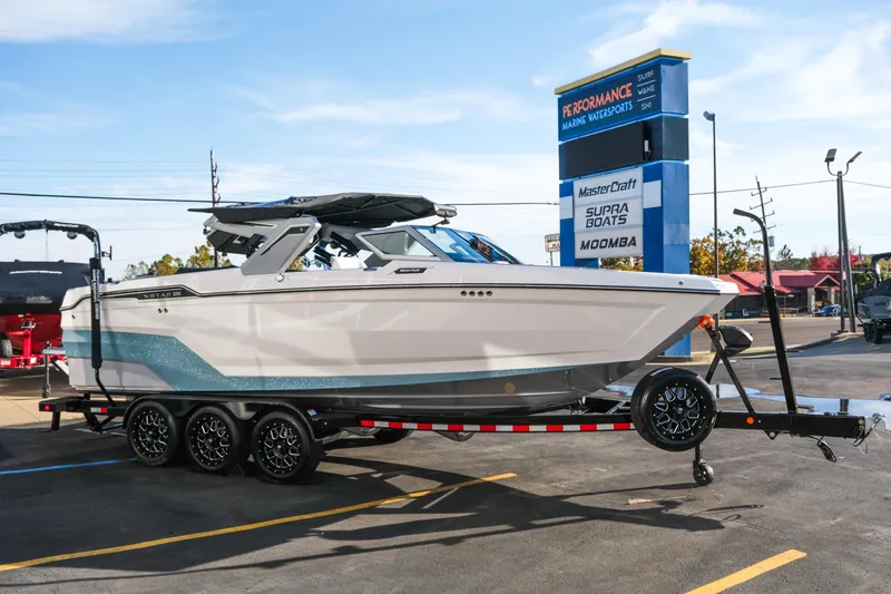 Slide: The Image of 2026 MasterCraft XStar 25 boat on trailer at dealership, sunny day. - 51