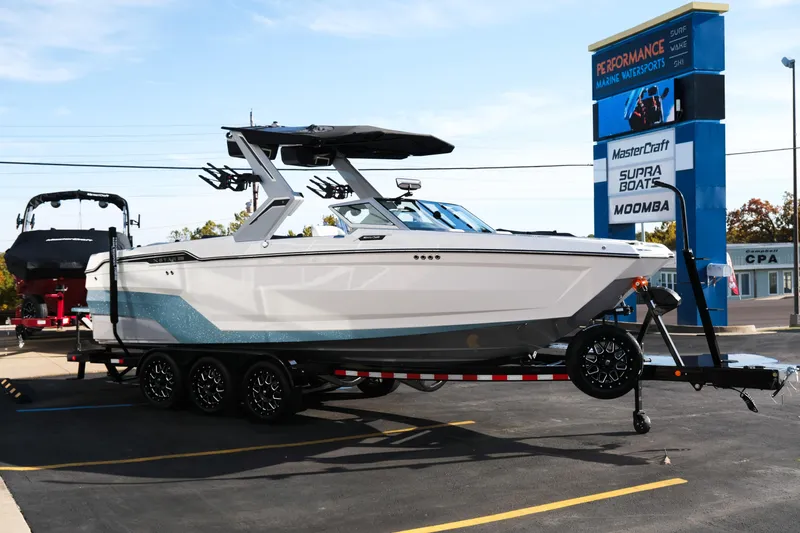 Slide: The Image of 2026 MasterCraft XStar 25 boat on trailer at dealership, showcasing sleek design. - 9
