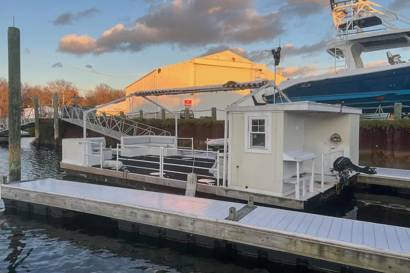 Slide: The Image of Custom MK1 2022 houseboat docked at marina, with clear sky and surrounding boats. - 4