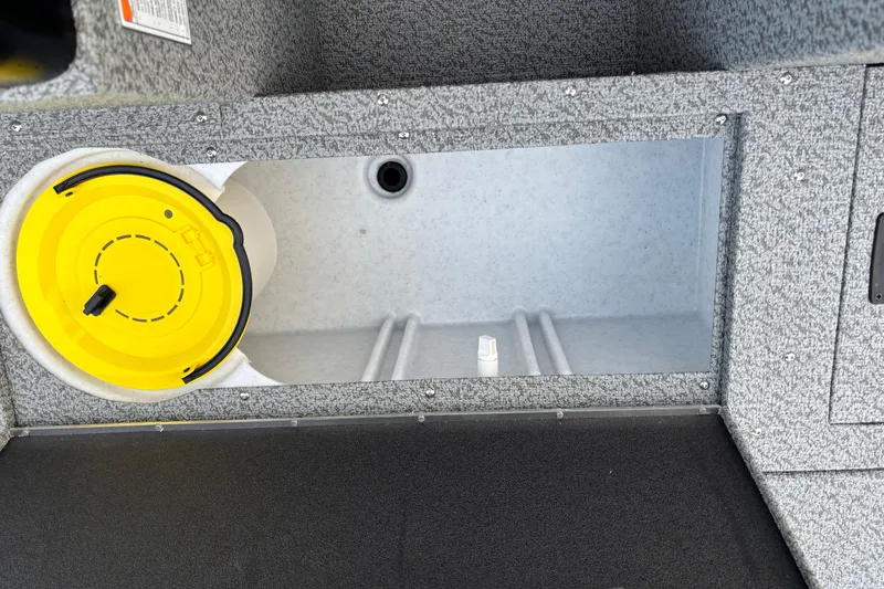 Slide: The Image of 2026 Crestliner 1650 Kodiak boat storage compartment with yellow lid and gray interior. - 9