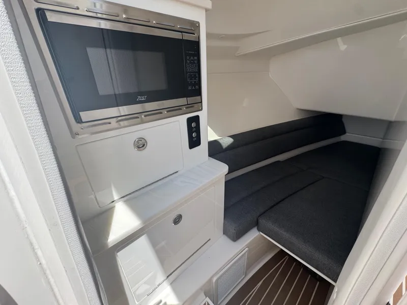 Slide: The Image of Interior of 2025 Fountain 39 DX boat with microwave and cushioned seating area. - 22