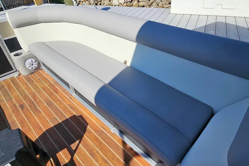 Slide: The Image of 2013 Crest 22 TriToon boat interior with gray seating and wooden deck. - 17