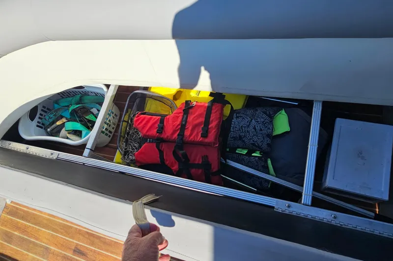 Slide: The Image of Storage compartment of 2013 Crest 22 TriToon boat with life jackets and gear. - 18