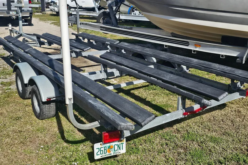 Slide: The Image of 2013 Crest 22 TriToon trailer parked on grass, showcasing dual-axle design. - 19