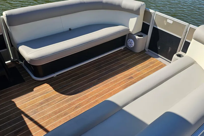 Slide: The Image of 2013 Crest 22 TriToon interior with cushioned seating and wooden deck flooring. - 3