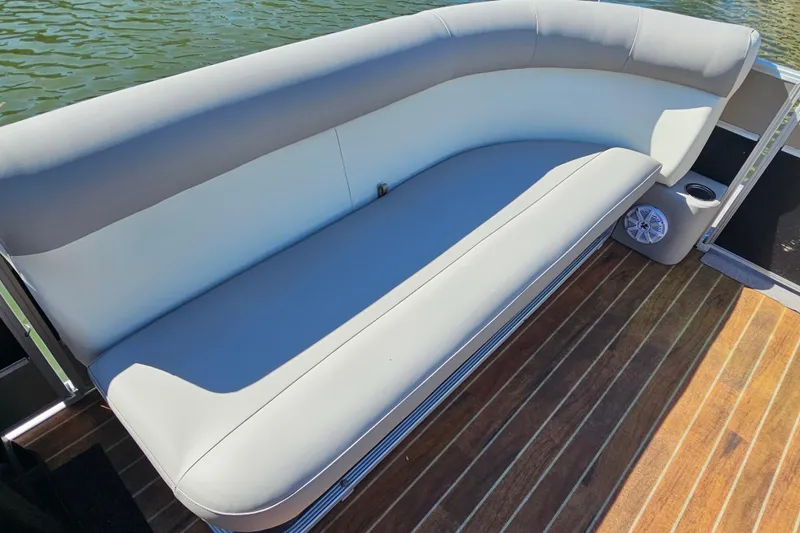 Slide: The Image of 2013 Crest 22 TriToon boat interior with cushioned seating and wooden deck. - 8