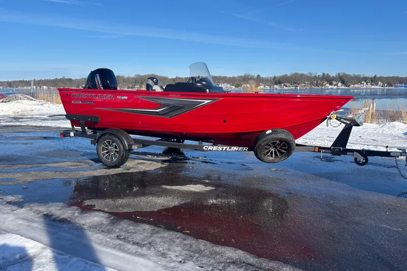 The Image of 2026 Crestliner 1650 Kodiak boat on trailer, vibrant red, snowy lakeside background. - 0