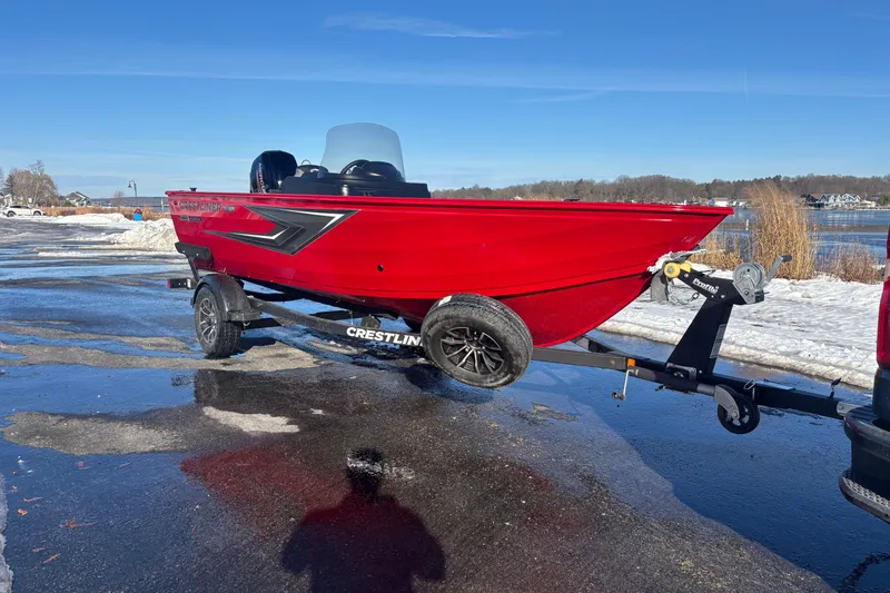 Slide: The Image of Red 2026 Crestliner 1650 Kodiak boat on trailer by snowy lakeside. - 11