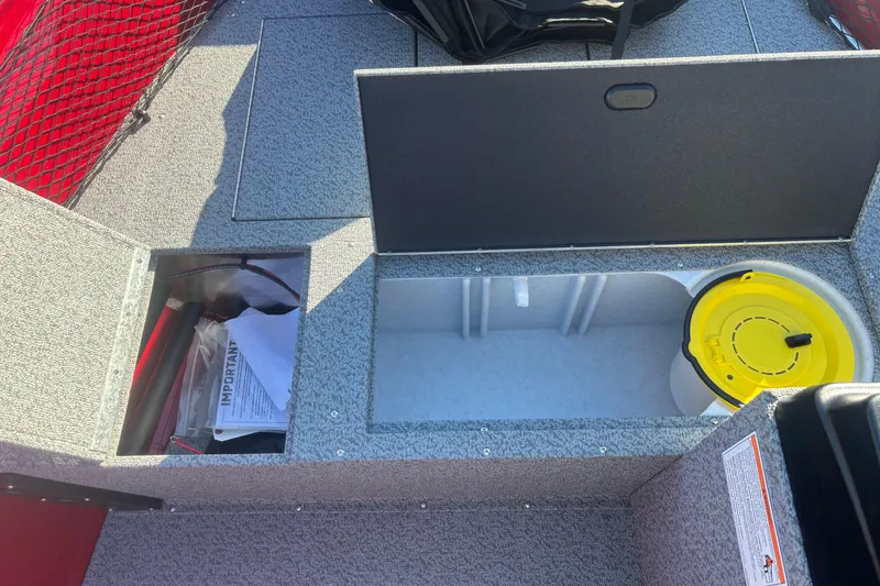 Slide: The Image of 2026 Crestliner 1650 Kodiak boat storage compartments with safety equipment and yellow container. - 4