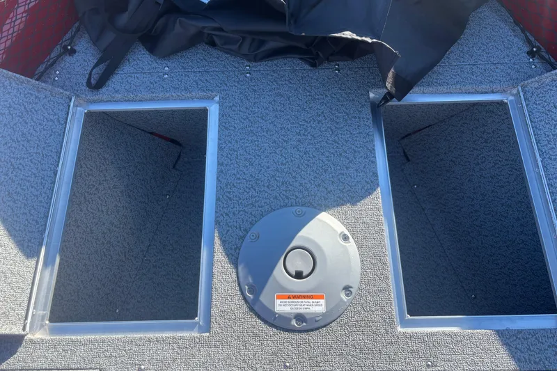 Slide: The Image of 2026 Crestliner 1650 Kodiak boat interior with storage compartments and carpeted flooring. - 5