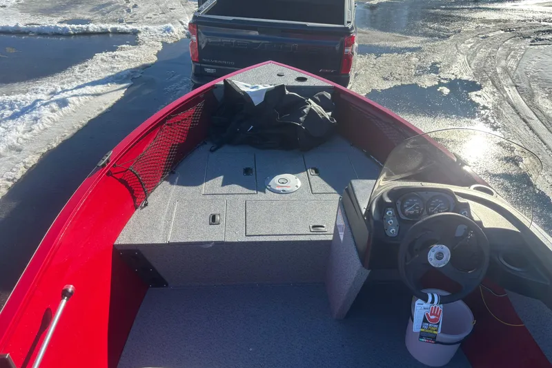 Slide: The Image of 2026 Crestliner 1650 Kodiak boat interior with steering wheel, parked near snowy area. - 7