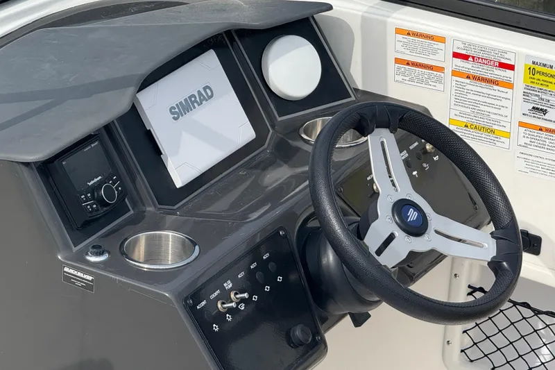 Slide: The Image of 2025 Bayliner VR6 Bowrider OB dashboard with steering wheel and Simrad display. - 8