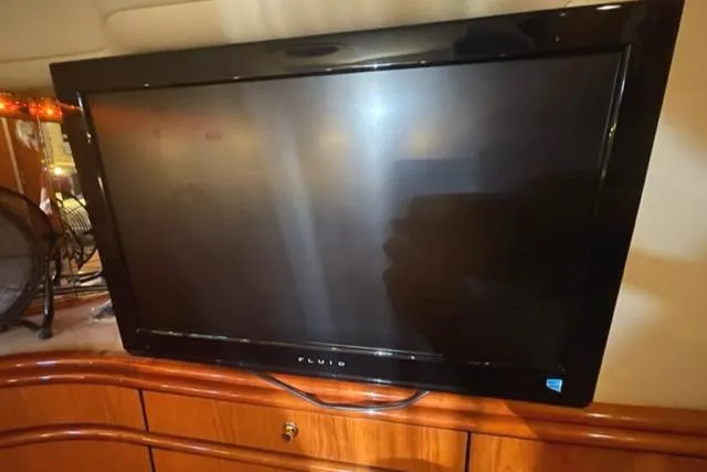 Slide: The Image of Flat-screen TV inside 2001 Sea Ray Sundancer 540 yacht, mounted on wooden cabinet. - 19