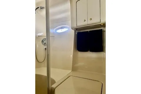 Slide: The Image of 2001 Sea Ray Sundancer 540 bathroom with shower, cabinet, and porthole window. - 23