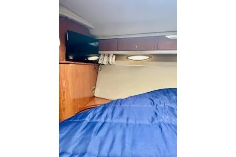 Slide: The Image of 2001 Sea Ray Sundancer 540 cabin interior with blue bedding and wall-mounted TV. - 29