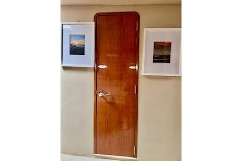 Slide: The Image of Wooden cabin door on 2001 Sea Ray Sundancer 540 yacht, flanked by framed photos. - 32