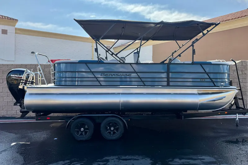 The Image of 2026 Berkshire 22RFX LE pontoon boat on trailer, featuring a Mercury outboard motor. - 0
