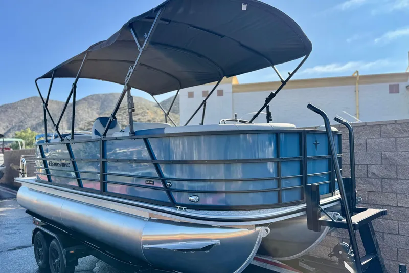 Slide: The Image of 2026 Berkshire 22RFX LE pontoon boat with canopy, parked outdoors. - 1