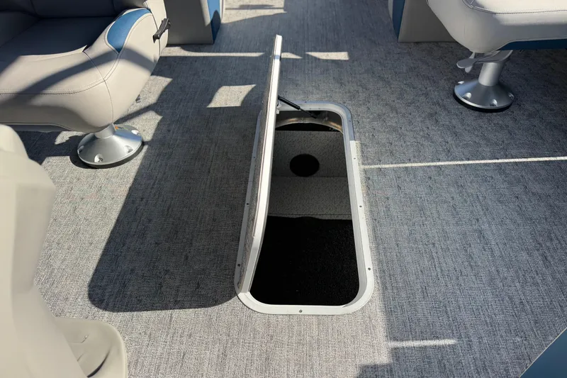Slide: The Image of 2026 Berkshire 22RFX LE boat interior with open storage compartment and seating. - 16